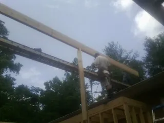 Carpenter setting a ridge beam over a new addition frame — Ice Dam Removal by Roofing Brothers in Mulvane