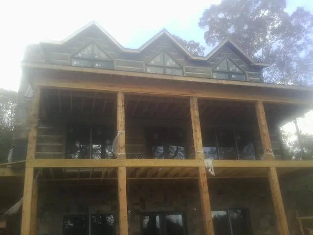 Dormers and porch framing on a large log home under construction — Roof Coating work by our crew in Mulvane