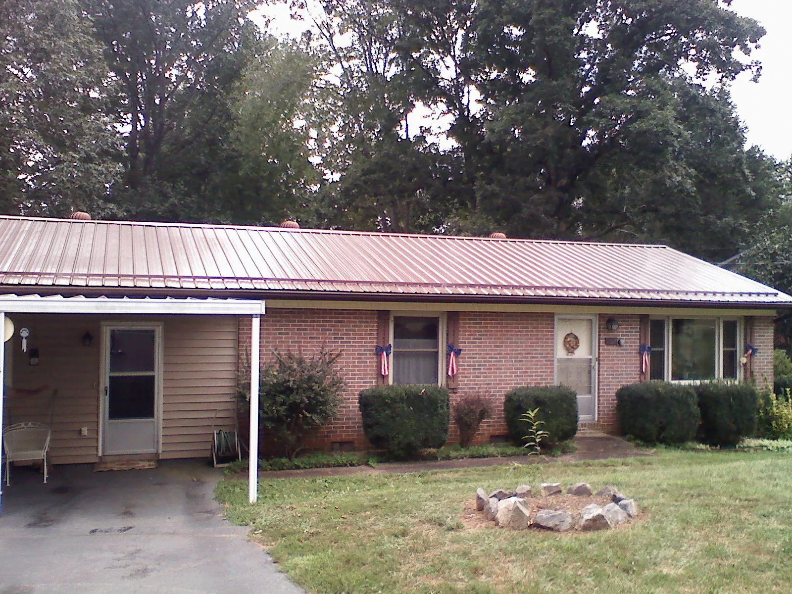 Bronze metal roof and carport on a brick ranch home — Roof Repair work by our crew in Mulvane