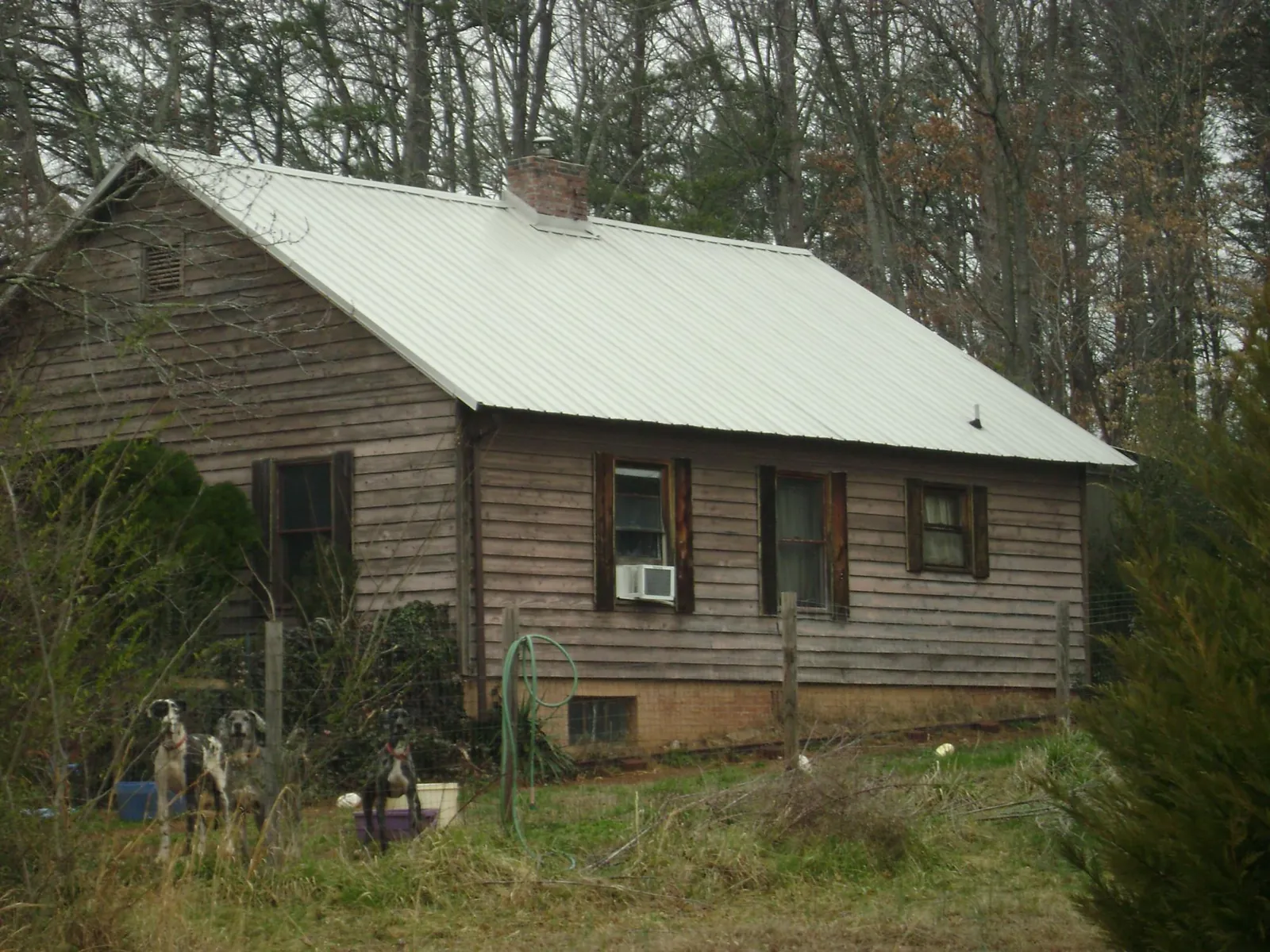 White metal roof on an old wood sided farmhouse, from a Metal Roof Installation job in Mulvane